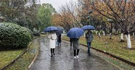 在雨中撐著傘的人 描述已自動生成